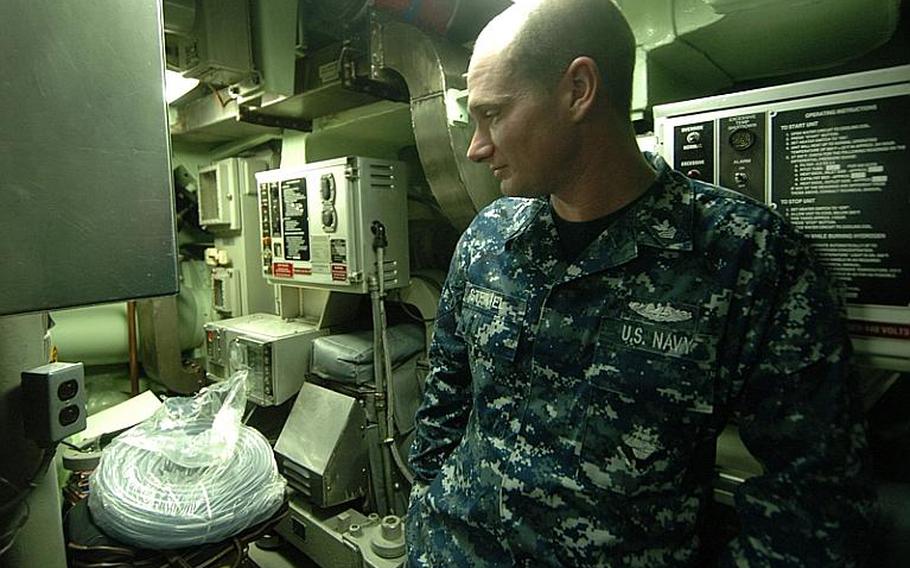 Petty Officer 1st Class John Steimel looks back at the storage area that used to be a designated smoking area aboard the fast-attack submarine USS Charlotte, during a port visit Thursday at Yokosuka Naval Base, Japan. 
