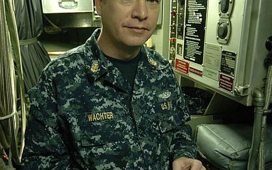 Chief Petty Officer Mark Wachter stands with a pack of nicotine chewing gum in what used to be a designated smoking area aboard the fast-attack submarine USS Charlotte, during a port visit Thursday at Yokosuka Naval Base, Japan. The Navy banned smoking on submarines as of Jan. 1 due to secondhand smoke exposure. 
