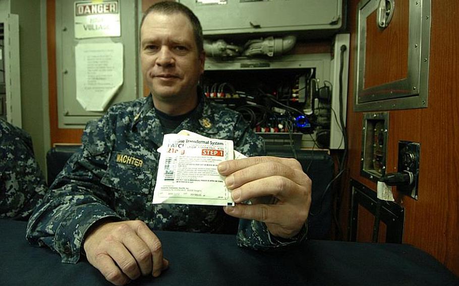 Chief Petty Officer Mark Wachter shows one of the nicotine patches distributed to sailors aboard the fast-attack submarine USS Charlotte, during a port visit Thursday at Yokosuka Naval Base, Japan. The Navy banned smoking on submarines as of Jan. 1 due to secondhand smoke exposure. 