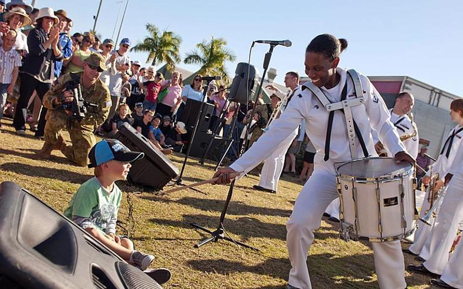 Musician 3rd Class Camellia Akhami gives a little boy a her drum sticks after the U.S. 7th Fleet Band Far East Edition's performance at the opening ceremony for the exercise Talisman Sabre 2011 in Rockhampton, Queensland, Australia. Talisman Sabre 2011 is a bilateral exercise designed to train Australian and U.S. Forces in planning and conducting Combined Task Force operations in order to improve Australian/U.S. combat readiness and interoperability. The exercise reflects the closeness, alliance and strength of the ongoing military-military relationship between the U.S. and Australia.