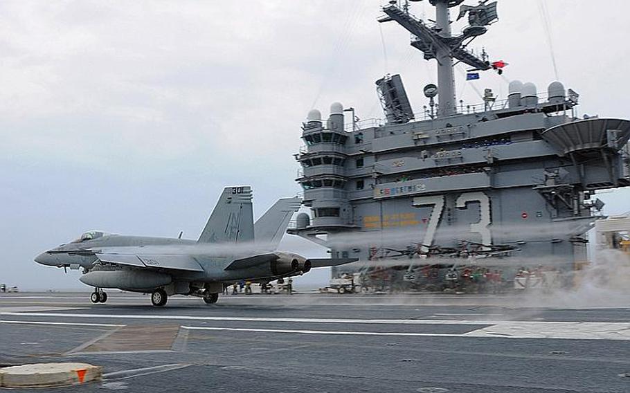 An F/A-18E Super Hornet assigned to the Eagles of Strike Fighter Squadron 115 conducts a touch-and-go landing aboard the aircraft carrier USS George Washington.