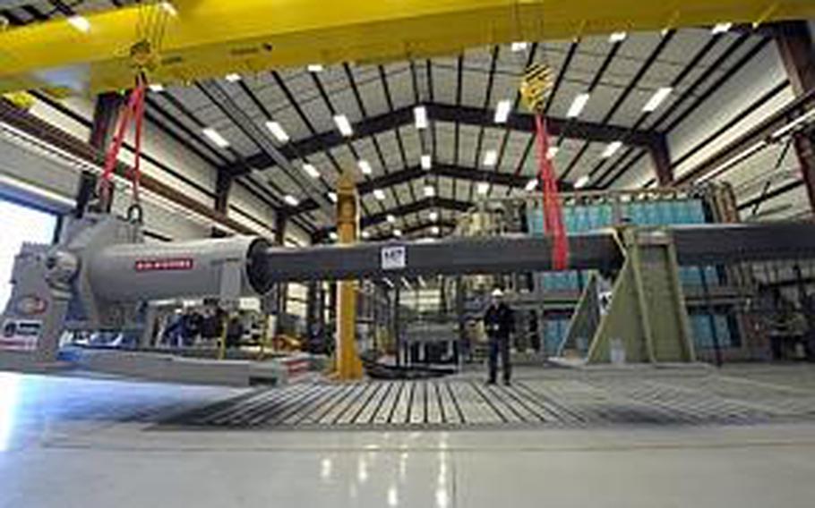 Gary Bass, of the Naval Surface Warfare Center in Dahlgren, Va., uses a crane to maneuver a 32-MJ version of the electromagnetic railgun prototype into place for testing. The railgun may someday be used to launch projectiles off ships at speeds over 5,000 mph.