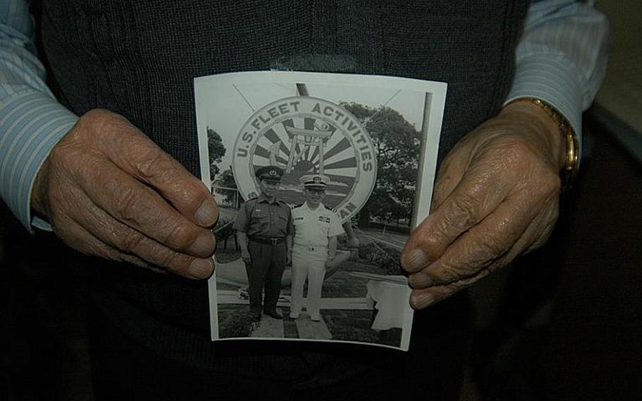 Mike "Daddy Mike" Yoneda has plenty of mementos from his 63 years of service to the U.S. Navy, including this photo of him, right, then a security officer, and a Japanese police official, cutting the ribbon to the Sasebo Naval Base sign and shrine that welcomes visitors to the base. Yoneda looked past internment during World War II and racism to rise as an officer in the Navy. After retiring from active duty, he gave more than 30 years of service as a civilian to Sasebo Naval Base, and had a hand in many of the projects and programs that sailors and their families enjoy today.