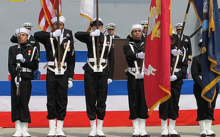 Capt. David Fluker, center, formerly of the USS Essex and now of the USS Bonhomme Richard salutes the colors April 23, 2012, during a hull swap ceremony at Sasebo Naval Base.