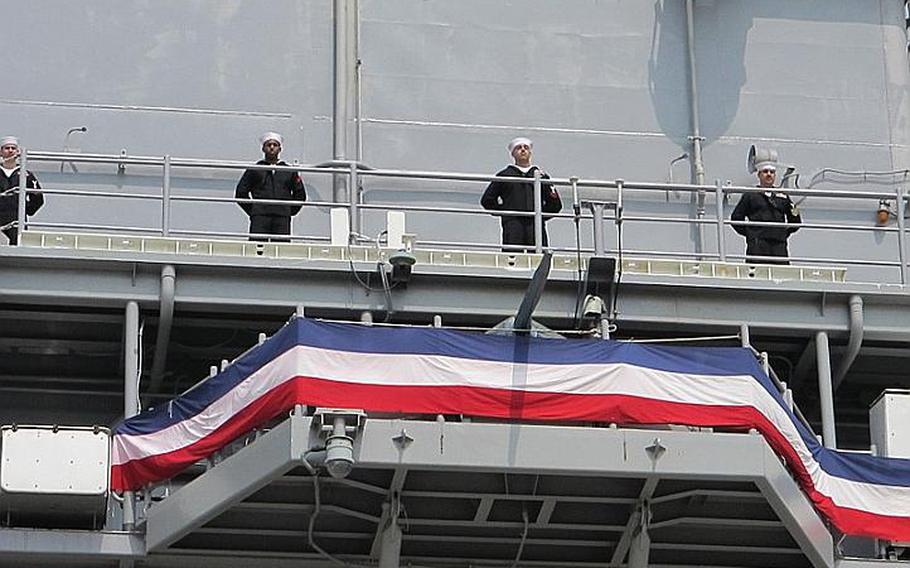 Former USS Essex sailors man the rails of the USS Bonhomme Richard following a hull swap ceremony April 23, 2012, at Sasebo Naval Base.