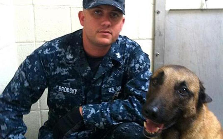 In this undated photo posted on a Facebook memorial page, Petty Officer 2nd Class Michael Brodsky poses with his military working dog. Brodsky died July 21 from injuries caused by a dismounted IED in Afghanistan.