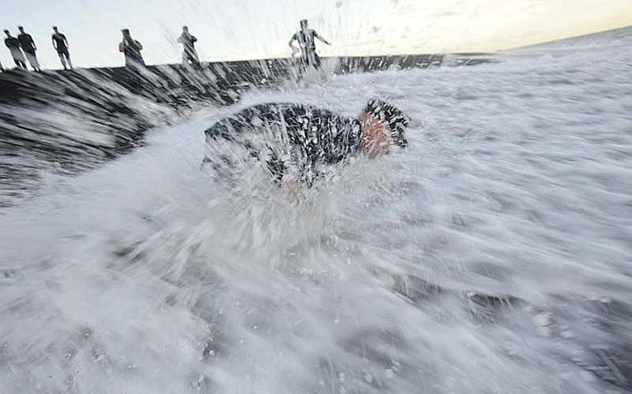 Chief Petty Officer Andrew Thomasson perseveres the powerful Iwo Jima tide Aug. 28, 2012, so he can fulfill his promise to his family and lay his grandfather's ashes to rest. During the Battle for Iwo Jima, Petty Officer 2nd Class Oscar Thomasson's landing craft was destroyed while making its way to the island during the U.S. forces' initial assault. Thomasson ultimately survived the battle and went on to raise a family near Wichita, Kan. He passed away Dec. 22, 2006, at age 80.