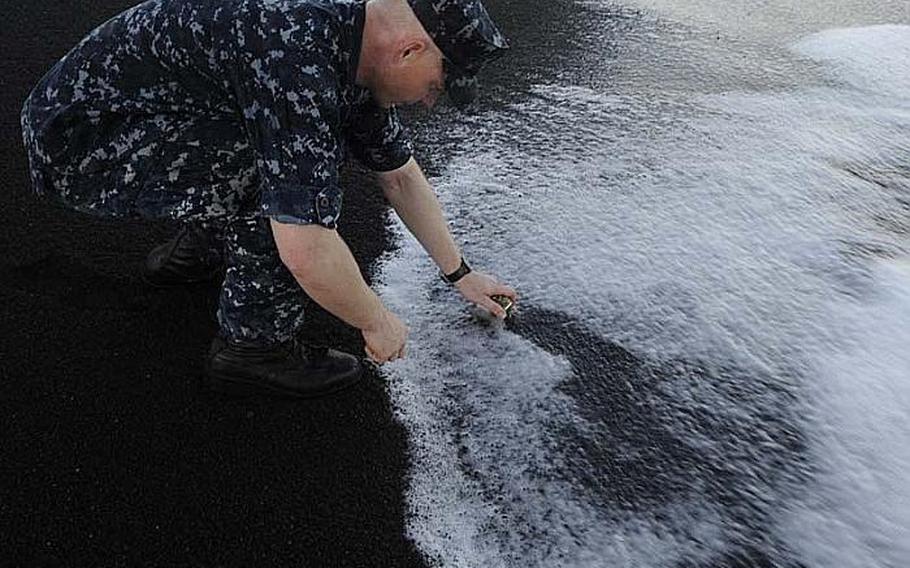 Chief Petty Officer Andrew Thomasson lays his grandfather's ashes to rest on Iwo Jima's Invasion Beach. Thomasson was with more than 60 chief petty officers and chief petty officer selectees taking part in a heritage trip that emphasized the historic significance for both U.S. and Japanese servicemembers who fought in the Battle for Iwo Jima during World War II.  Thomasson's grandfather took part in the initial U.S. invasion of the island. He later went on to raise a family near Wichita, Kan., and passed away at the age of 80.