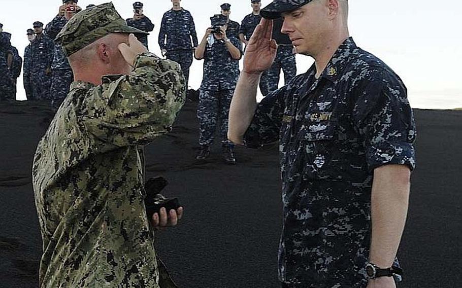 Chief Select Joshua Ward, left, presents Chief Petty Officer Andrew Thomasson with his grandfather's ashes during a ceremony this week on Iwo Jima. Thomasson's grandfather was a survivor of the Battle for Iwo Jima and was part of the initial U.S. forces' invasion. Petty Officer 2nd Class Oscar Thomasson's landing craft was destroyed while making its way to the island during the battle's initial assault. He ultimately survived the battle and went on to raise a family near Wichita, Kan. He passed away Dec. 22, 2006, at age 80.
