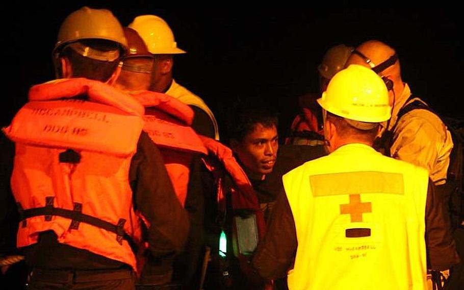 A fisherman boards the USS McCampbell after being rescued with four other crewmembers from a sinking boat, about 50 miles from the coast of The Philippines Philippines about 1 a.m. Oct 24, 2012. A Navy Seahawk helicopter crew noticed a flicker of light from the sinking ship while conducting night operations, according to the pilots.