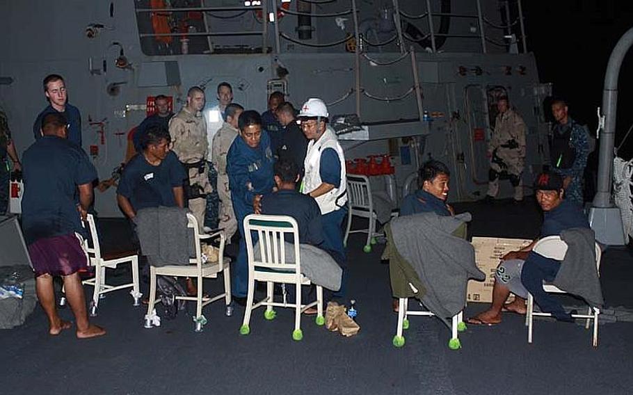 Five fisherman rest and recieve medical evaluations on board the USS McCampbell after being rescued from their sinking ship, about 50 miles from the coast of The Philippines about 1 a.m. Oct 24, 2012. A Navy Seahawk helicopter crew noticed a flicker of light from the sinking ship while conducting night operations, according to the pilots.
