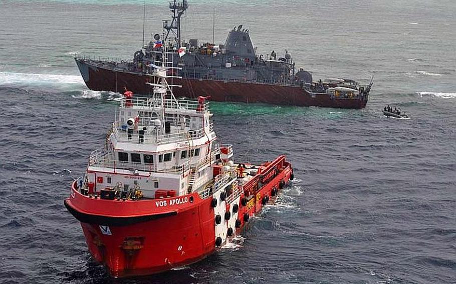 Malaysian tug Vos Apollo prepares for defueling operations near the grounded USS Guardian on Jan. 24, 2013, while a U.S. Navy small boat approaches with a salvage team. The U.S. Navy contracted Vos Apollo to assist with removing fuel from the mine countermeasures ship, which ran aground on the Tubbataha Reef in the Sulu Sea on Jan. 17. No fuel has leaked since the grounding and all of the approximately 15,000 gallons onboard Guardian was safely transferred to Vos Apollo during two days of controlled defueling operations on Jan. 24 and Jan. 25.