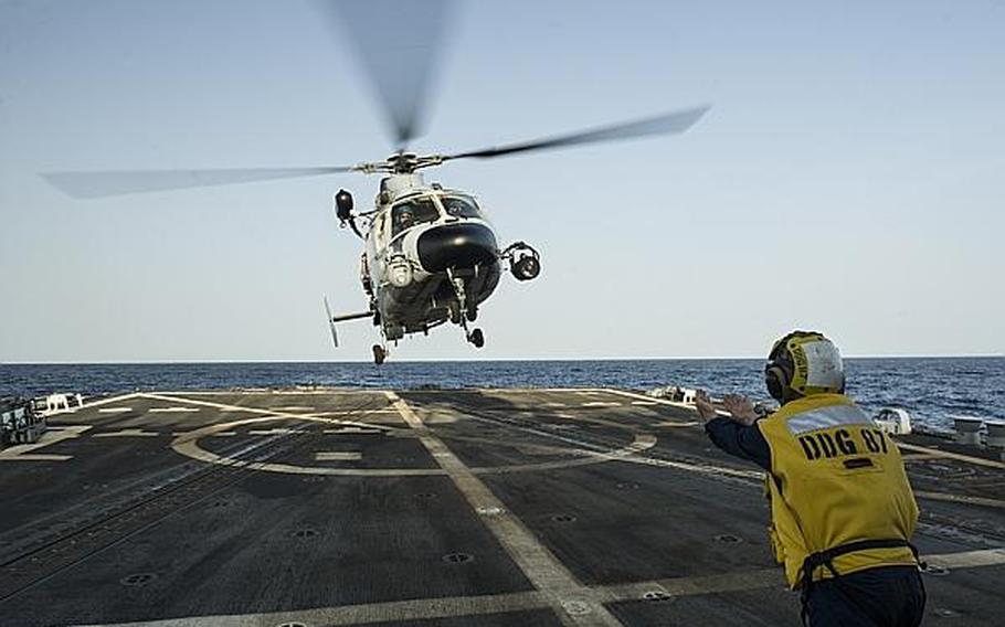 Seaman Alexander Mohney, a boatswain's mate, guides a Chinese Harbin Z-9C helicopter to the flight deck of the guided-missile destroyer USS Mason during counter-piracy training with the Chinese destroyer Harbin on Aug. 24, 2013, in the Gulf of Aden. The Mason is deployed in support of maritime security operations and theater security cooperation efforts in the U.S. 5th Fleet area of responsibility.

