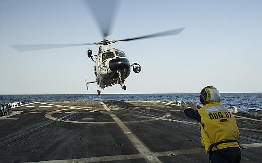 Seaman Alexander Mohney, a boatswain's mate, guides a Chinese Harbin Z-9C helicopter to the flight deck of the guided-missile destroyer USS Mason during counter-piracy training with the Chinese destroyer Harbin on Aug. 24, 2013, in the Gulf of Aden. The Mason is deployed in support of maritime security operations and theater security cooperation efforts in the U.S. 5th Fleet area of responsibility.