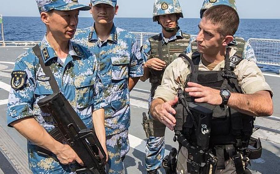 Lt. j.g. Jeffrey Fasoli, a gunnery officer aboard the guided-missile destroyer USS Mason, discusses techniques with sailors aboard the Chinese destroyer Harbin prior to a combined small-arms exercise in the Gulf of Aden on Aug. 24, 2013.

