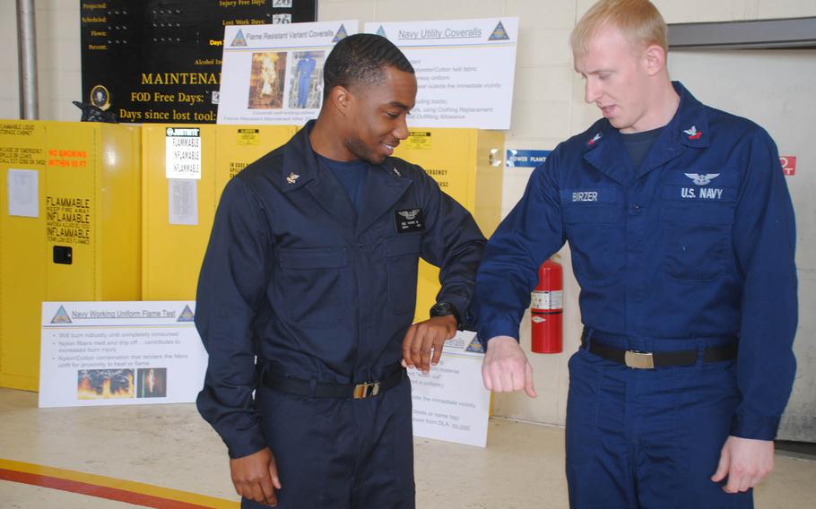 Petty Officer 2nd Class Martin Vories, left, an operations specialist, compares his flame-resistant coveralls with standard coveralls worn by Petty Officer 2nd Class Mark Birzer, an aviation machinist's mate. The Navy announced a slew of uniforms changes Tuesday aimed at reducing the number of uniforms a sailor needs and phasing out some clothing by Oct 1.