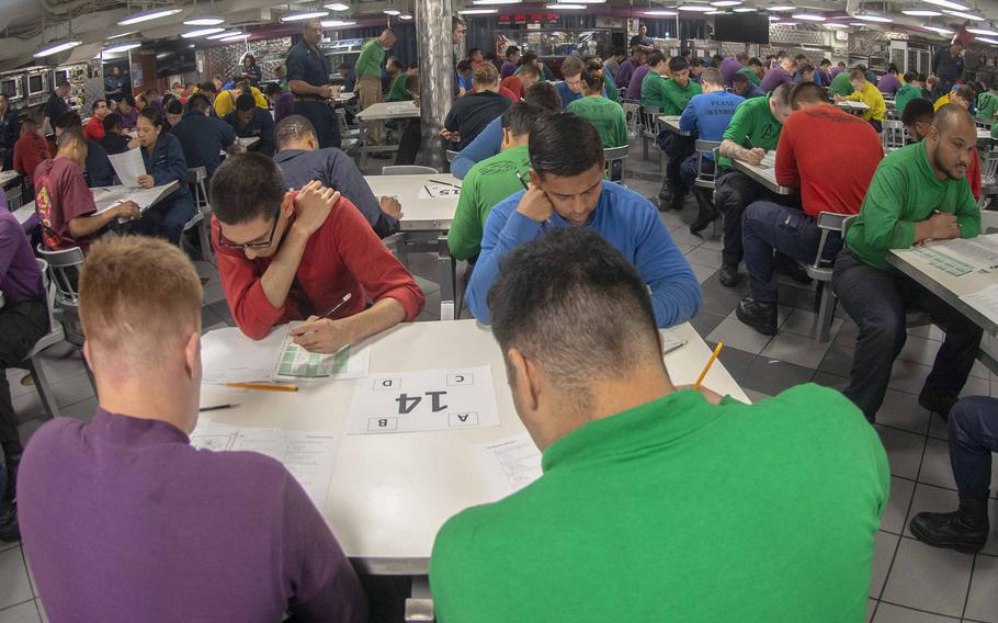 Sailors take the E-4 advancement exam on the mess decks aboard the aircraft carrier USS Ronald Reagan in the Philippine Sea in September 2019. The Navy has scrapped the test for the pay grade this cycle due to coronavirus concerns.