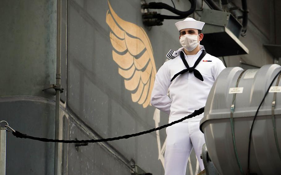 A sailor mans the rails aboard the USS Theodore Roosevelt as the aircraft carrier prepares to depart Naval Base Guam, June 4, 2020.