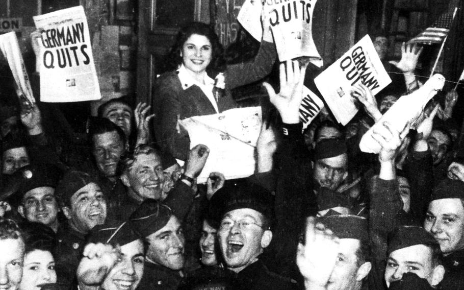 Victory in Europe day celebration. The revelers hold a copy of the May 8, 1945, London edition of the Stars and Stripes.