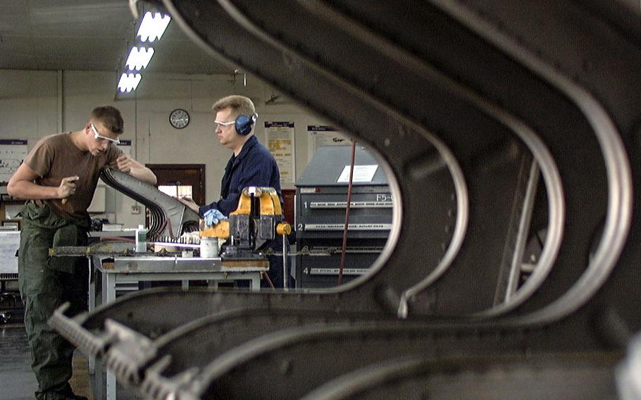 Tech. Sgt. Paul Cotto, right, and Airman 1st Class Matthew Bryan, sheet metal specialists with the 374th Maintenance Squadron, repair the leading edge of the wing of a C-130 aircraft at the squadron’s structural maintenance shop.