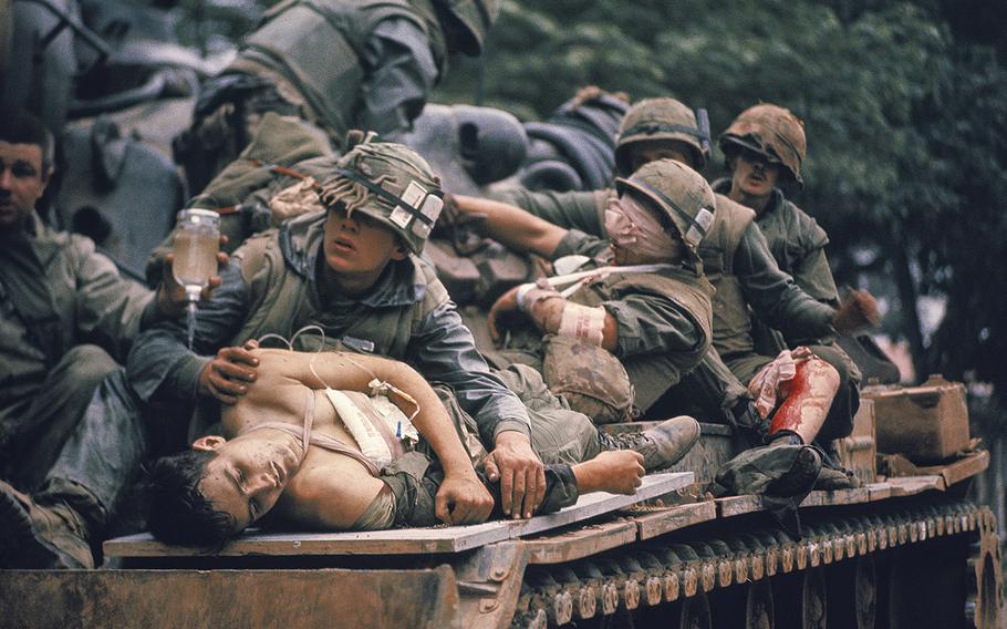 A.B. Grantham, foreground, and other wounded U.S. Marines are evacuated on a tank at Hue, South Vietnam, during the Tet offensive in February 1968. 
