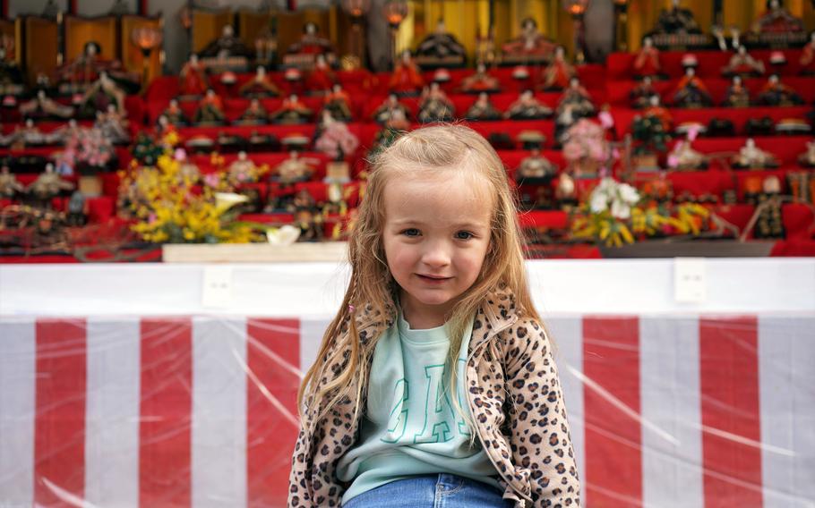 Emersyn Thomas, 3, whose father is stationed at Camp Zama, poses in front of tiers of hina dolls on Girls' Day at Zama Shrine, March 3, 2023.