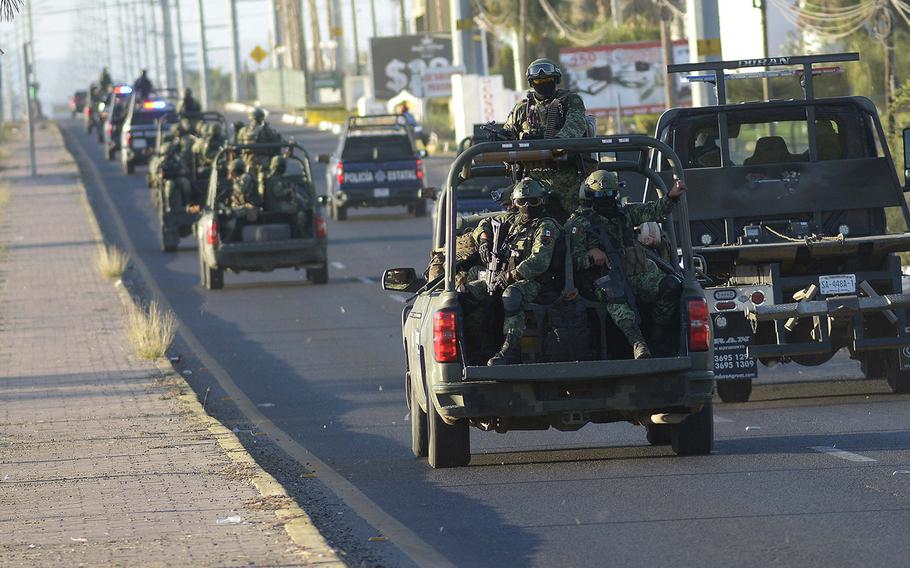 Members of the Mexican army drive on a road a day after an operation to arrest the son of Joaquin "El Chapo" Guzman, Ovidio Guzman, in Culiacan, Sinaloa state, Mexico, on Jan. 6, 2023. 