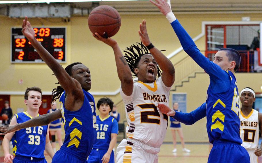 Baumholders Johnathan Kimuli tries to take it to the hoop between Sigonellas Deshawn Wallace, left, and Christopher Hedemand. Top seed Baumholder beat the Jaguars 54-40, in a D-III game on opening day of the DODEA-Europe basketball finals in Baumholder, Germany, Feb. 15, 2023. 