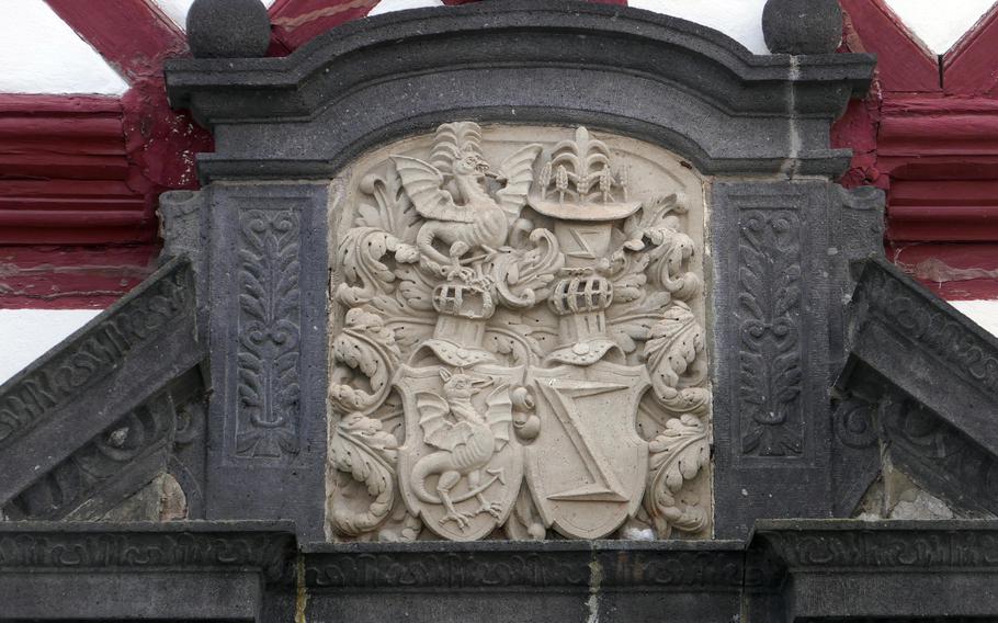 The combined coats of arms of the von Bredenbach-Buerresheim and von Metzenhausen families above the doorway of the amtshaus, a half-timbered building at Buerresheim Castle, near Mayen, Germany.