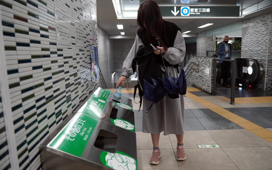 A commuter throws away a plastic bottle at Hibiya Station in central Tokyo, Wednesday, April 27, 2022. 