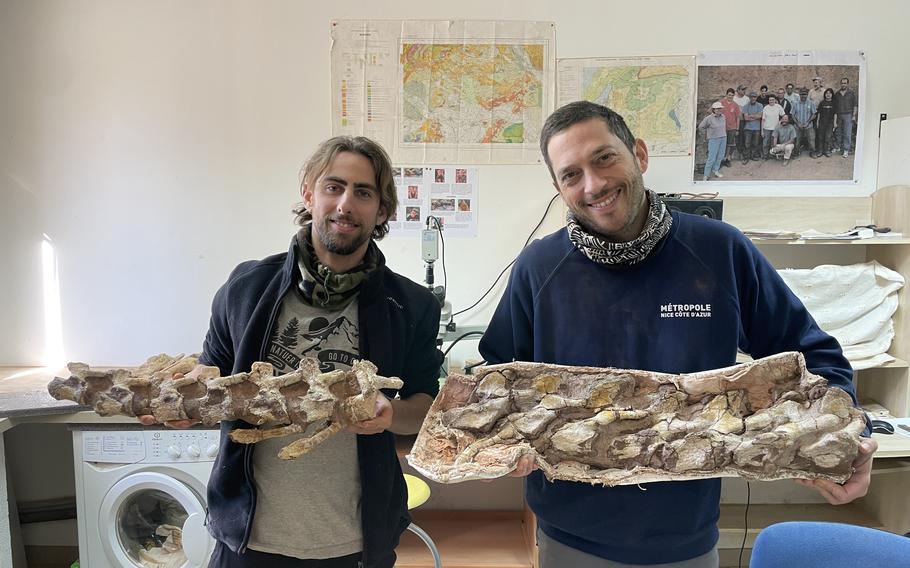 Damien Boschetto, left, holds bones from his dinosaur discovery with Jean-Marc Veyssières, one of the archaeological team members working on the dig. 