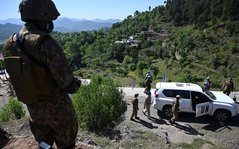 A Pakistani soldier stands guard on a post as a vehicle carrying UN military observers arrives to visit near the Line of Control, de facto border between India and Pakistan at Salohi village in Poonch district of Pakistan-administered Kashmir on April 26, 2021. 