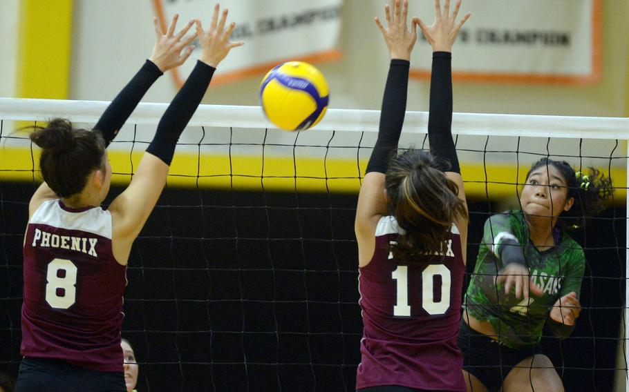 Kubasaki's Risha McGriff launches a spike between Seisen International's Lisa Purcell and Aina Sekidol. McGriff led the Dragons with 14 kills.