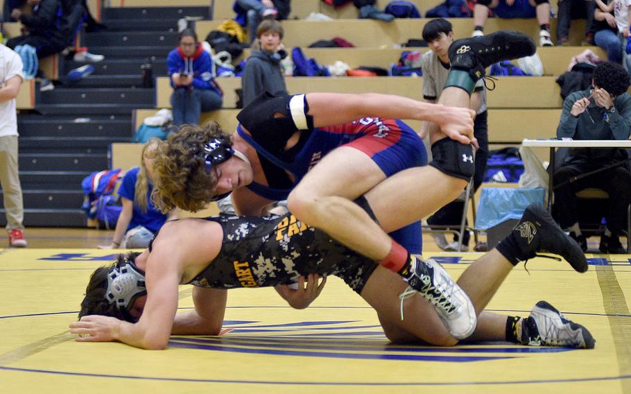 Ramstein's Lucas Hollenbeck locks the leg of Stuttgart's Jace Holmes during the 165-pound final at the Warrior Wraggle on Jan. 13, 2024, at Wiesbaden High School in Wiesbaden, Germany.