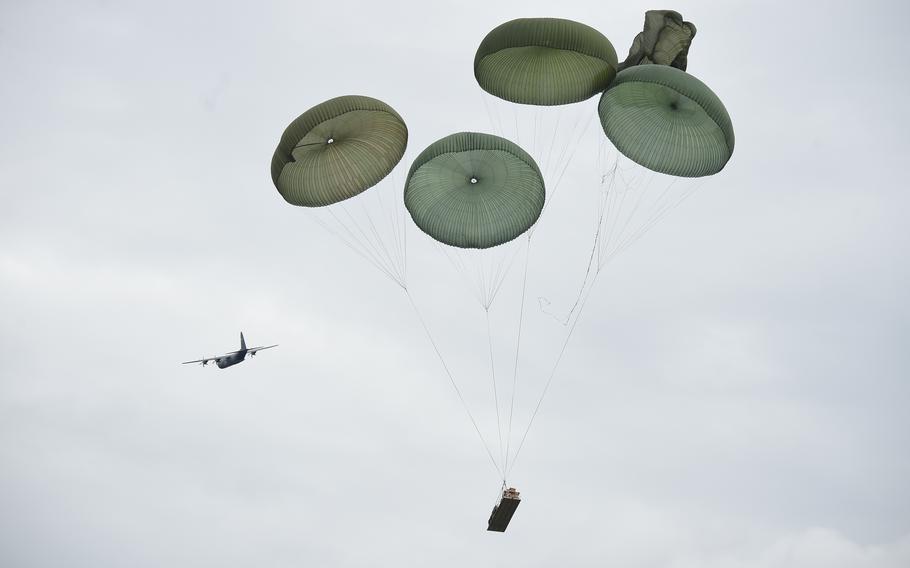 An M119A3 howitzer and a tactical vehicle are dropped from a C-130 aircraft during exercise Saber Junction at the Hohenfels Training Area in Germany, Sept. 8, 2022. The exercise tests the 173rd Airborne Brigade’s ability to move heavy equipment.