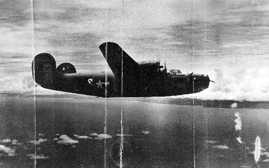 This black and white photo shows the World War II B-24 bomber, Heaven Can Wait, flying in the air.