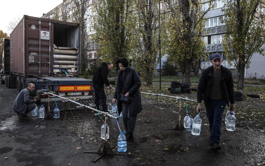Irina Nasietkina, 55, an unemployed engineer, collects fresh water for her son at a delivery truck in Mykolaiv, Ukraine. 