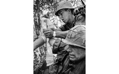 https://www.stripes.com/news/can-t-believe-i-m-in-one-piece-1.345340
Kim Ki Sam/Stars and Stripes
South Vietnam, 1966: A 1st Battalion, 27th Infantry "Wolfhounds" radioman bandages the arm of his battalion commander, Maj. Guy S. Meloy III, during Operation Attleboro in the jungles of Tay Ninh Province. Meloy, the son of the former commander of U.S. Forces in Korea, eventually rose to the rank of major general.