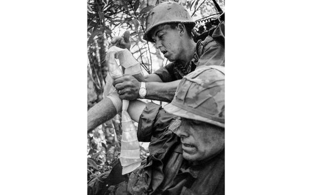 https://www.stripes.com/news/can-t-believe-i-m-in-one-piece-1.345340
Kim Ki Sam/Stars and Stripes
South Vietnam, 1966: A 1st Battalion, 27th Infantry "Wolfhounds" radioman bandages the arm of his battalion commander, Maj. Guy S. Meloy III, during Operation Attleboro in the jungles of Tay Ninh Province. Meloy, the son of the former commander of U.S. Forces in Korea, eventually rose to the rank of major general.