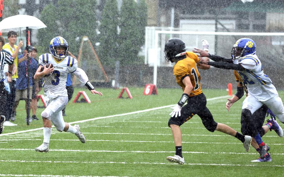 Yokota quarterback Dylan Tomas skirts around right end as American School In Japan's Jay Dossor gives chase and Panthers teammate DeShawn Bryant tries to block during Saturday's rain-drenched Kanto Plain football game at Mustang Valley. The Mustangs led 14-6 with 9:42 left when the game was called due to lightning and rescheduled for Oct. 28 at Yokota.