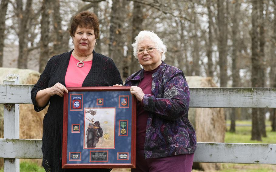 Merryman’s mother, Terry Bryant, 61, and his grandmother Jeanne Irvine, 84, hold a display of Merryman’s medals. 