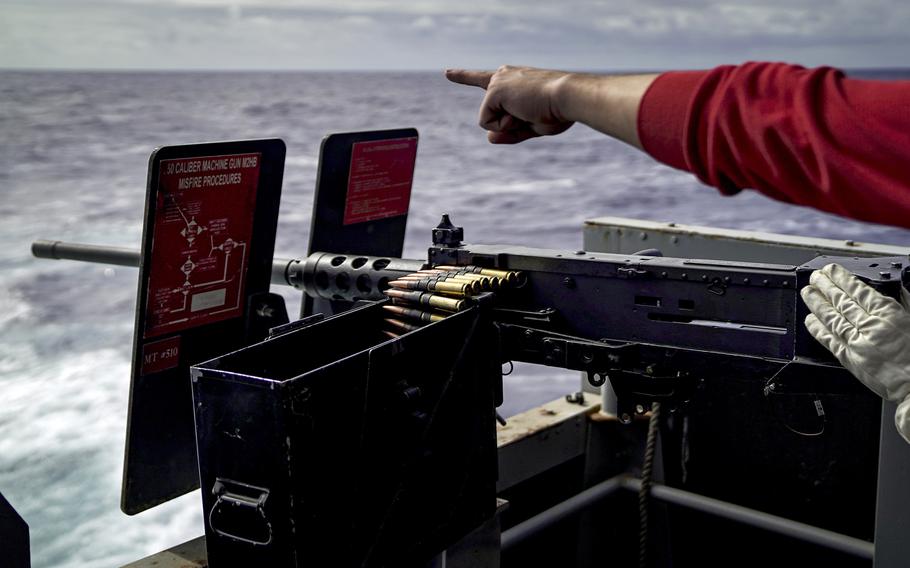 Sailors fire an M2HB .50-caliber machine gun on the fantail of the aircraft carrier USS Carl Vinson while in transit to Hawaii, Saturday, Aug. 7, 2021. 