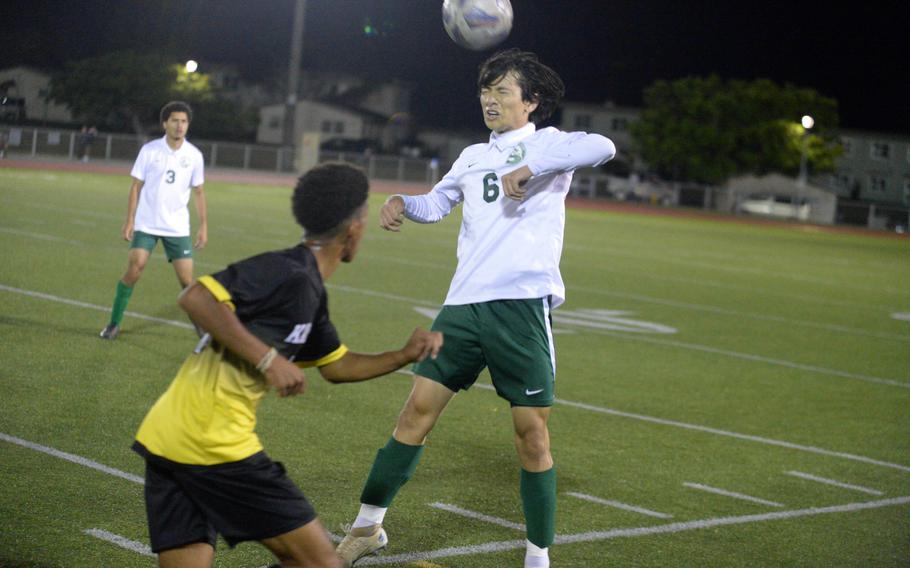 Kubasaki's Allan Tennison heads the ball in front of Kadena's Youshua Whipp during Wednesday's Okinawa boys soccer match. The Panthers edged the Dragons 3-2.