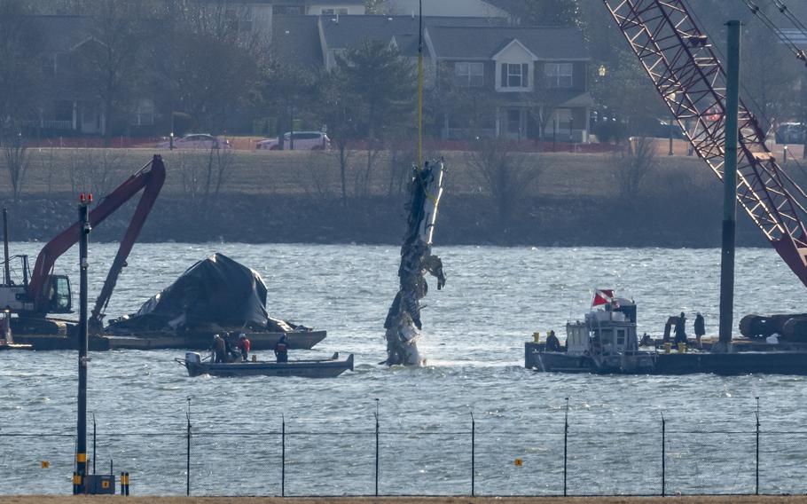 A piece of wreckage is lifted from the water