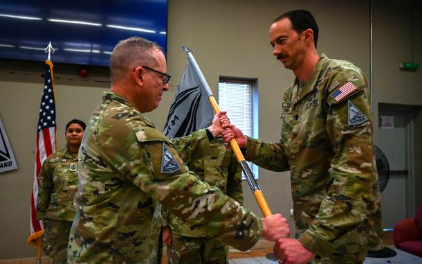 Space Force Col. Christopher Putman, left, U.S. Space Forces Central commander, passes the guidon to Lt. Col. Deane Lake, leader of combat detachment 3-1, at a ceremony March 12, 2024.