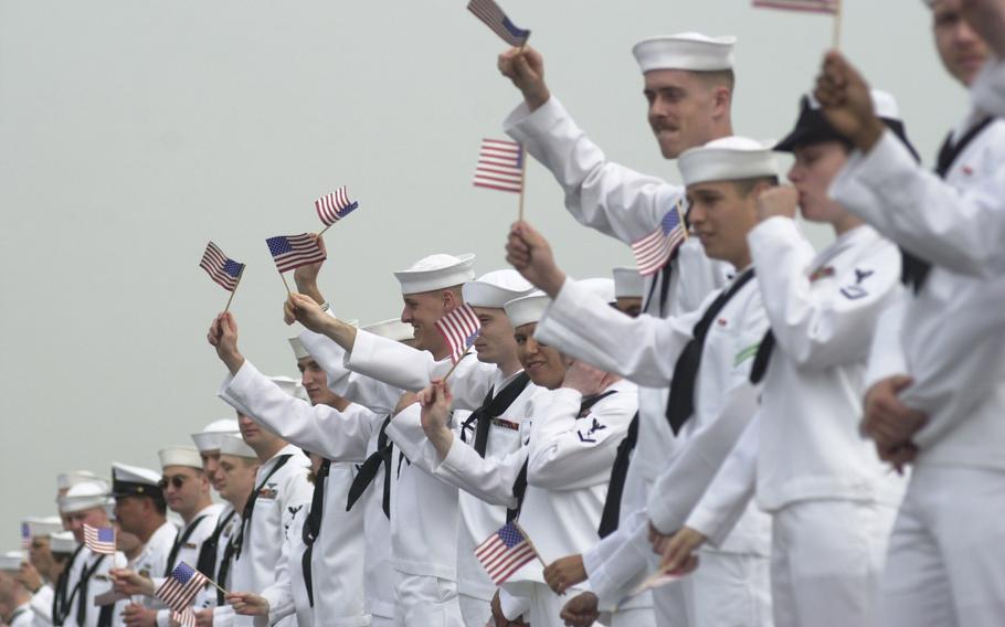 Kitty Hawk sailors wave flags as they man the rails Tuesday morning, May 6, 2003. The ship came home to Yokosuka after a four-month deployment to the Persian Gulf.