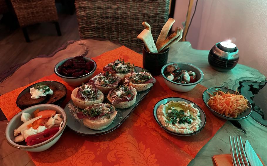 The pao de queijo appetizer surrounded with the house assortment of homemade bread, hummus and other vegetables, at Casa do Brasil steakhouse in Vilseck, Germany. 