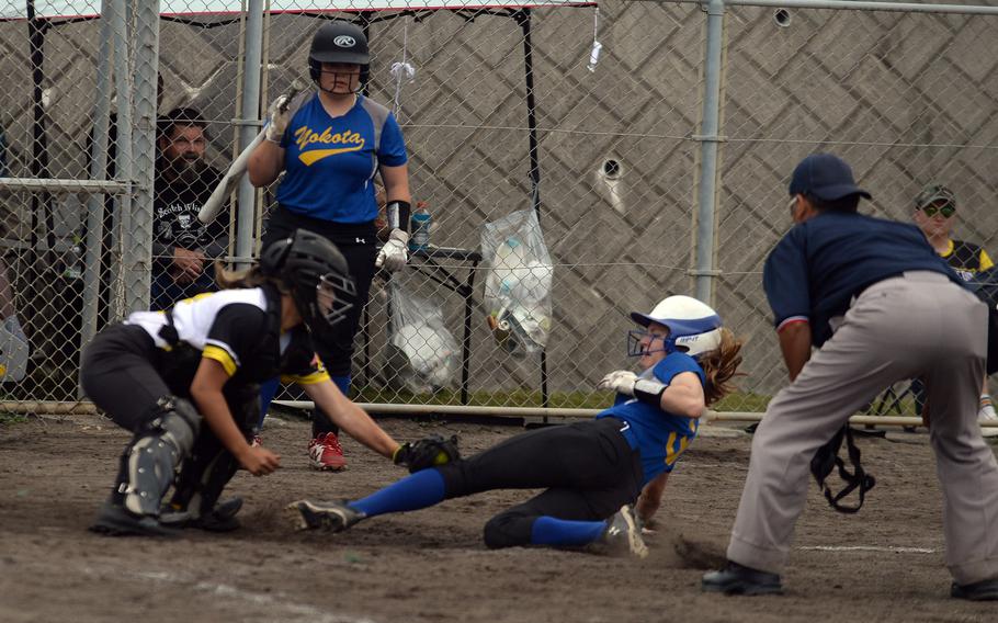 Yokota's Charlotte Rhyne is tagged out at home by Kadena catcher Lia Connolly.
