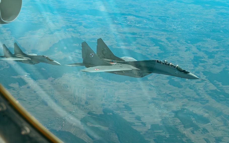 Two Poland Air Force MiG-29s fly alongside a B-52H Stratofortress assigned to the 69th Expeditionary Bomb Squadron at RAF Fairford, England, during a sortie in Poland, Feb. 24, 2022. 