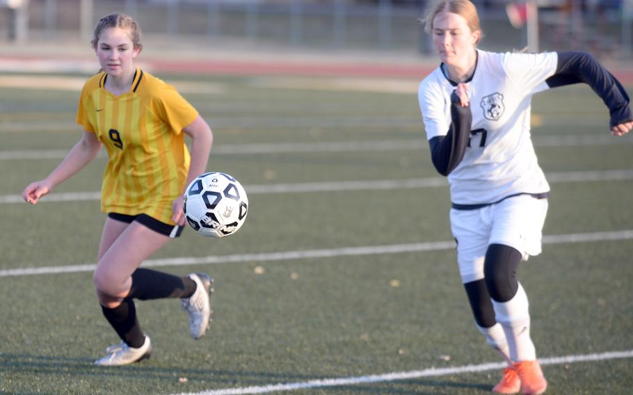 Robert D. Edgren's Abigail Erler and Zama's Lorelei Holt chase the ball during Friday's DODEA-Japan soccer match. The Trojans won 3-0.